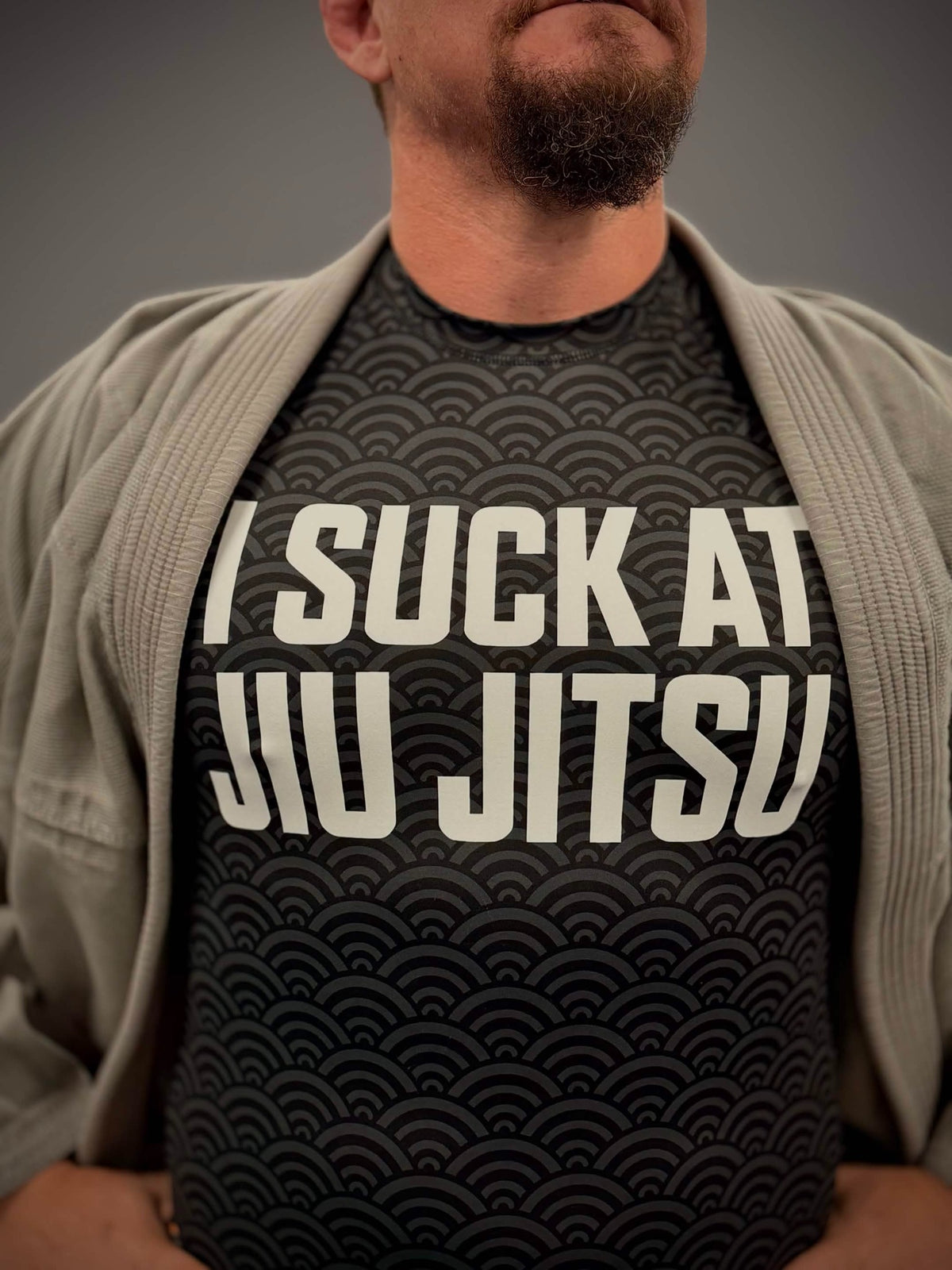 Close detail of Mat Theory I Suck at Jiu Jitsu rashguard