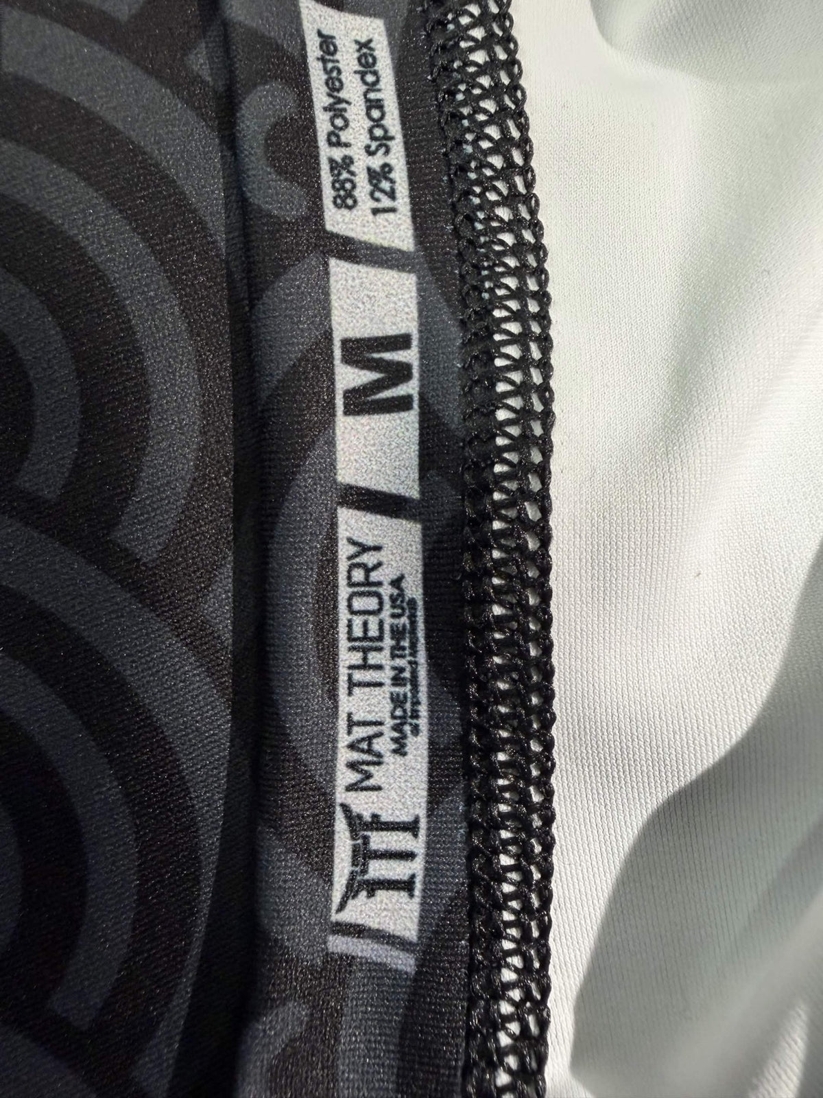 Mat Theory rashguard fabric and size label